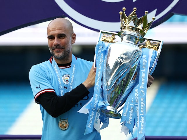 Le manager de Manchester City, Pep Guardiola, pose avec le trophée alors qu'il célèbre après avoir remporté la Premier League le 21 mai 2023