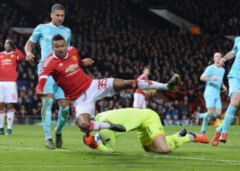 Le gardien de but néerlandais du PSV Eindhoven Jeroen Zoet (ci-dessous) défend le ballon du milieu de terrain anglais de Manchester United Jesse Lingard (3e L) lors de leur match de football du groupe B de l'UEFA Champions League entre Manchester United et le PSV Eindhoven à Old Trafford S