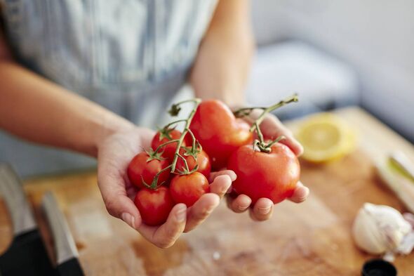 Tomates tenues dans les mains