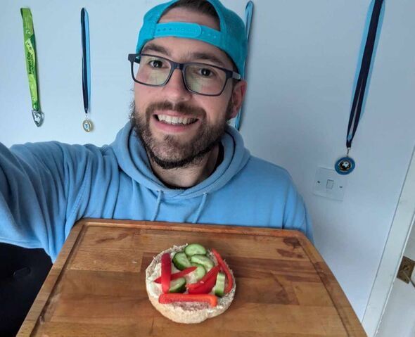 Matt tient une planche à découper avec un sandwich ouvert.