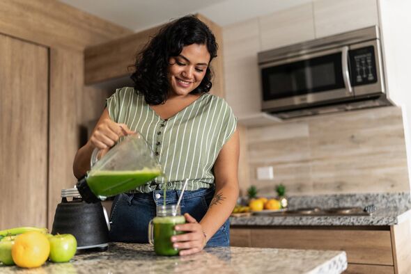 Jeune femme préparant du jus de désintoxication 