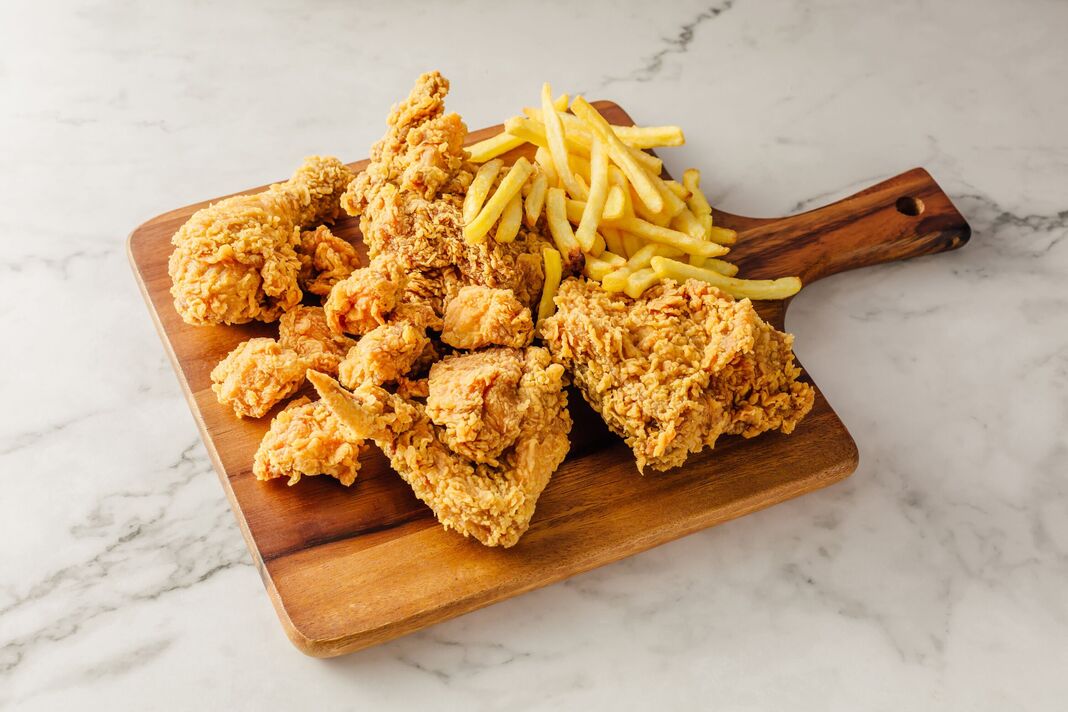 Poulet frit et frites sur fond blanc