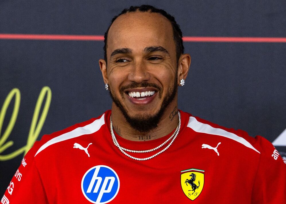 Lewis Hamilton souriant dans une chemise Ferrari rouge