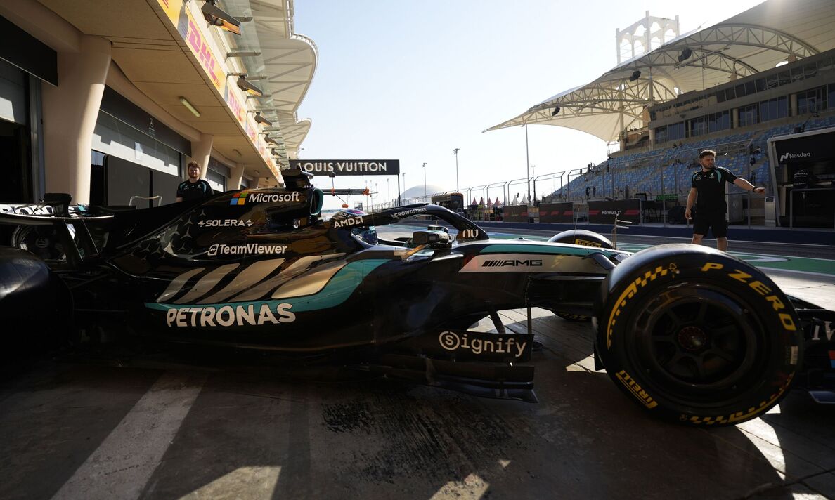 Voiture Mercedes F1 sortant du garage au coucher du soleil